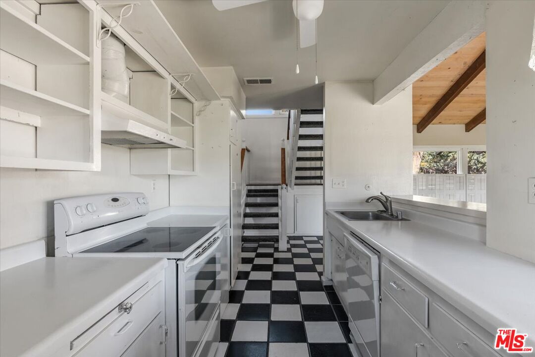 57 Meadow Lakes Drive Tehachapi, CA 93561 - Photo 13 of 26 a kitchen with a sink a stove and cabinets
