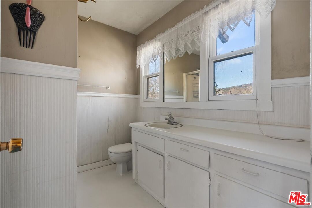 57 Meadow Lakes Drive Tehachapi, CA 93561 - Photo 19 of 26 a bathroom with a granite countertop toilet sink and mirror