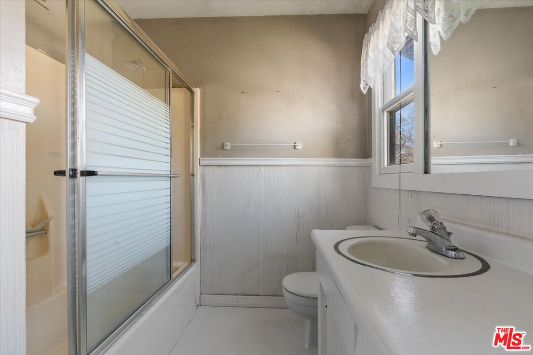 57 Meadow Lakes Drive Tehachapi, CA 93561 - Photo 20 of 26 a bathroom with a sink and mirror with toilet