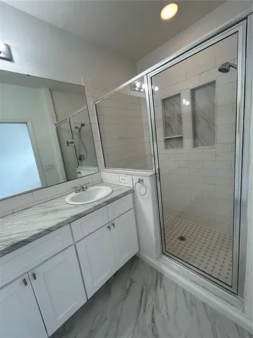 a bathroom with a shower sink and mirror