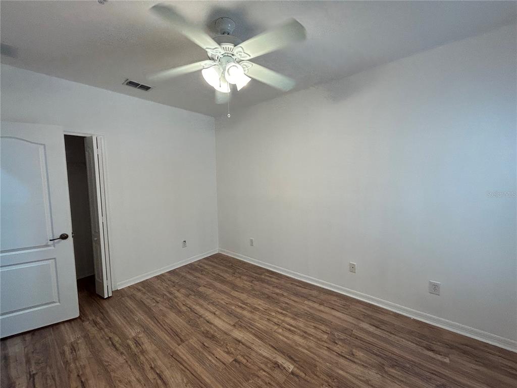 3121 Capri Isle Way Orlando, FL 32835 - Photo 21 of 37 an empty room with wooden floor and ceiling fan
