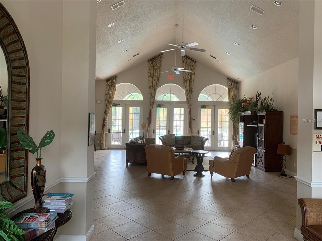 3121 Capri Isle Way Orlando, FL 32835 - Photo 25 of 37 a living room with furniture a chandelier and a large window