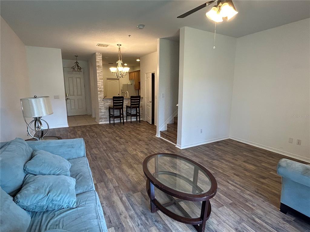 3121 Capri Isle Way Orlando, FL 32835 - Photo 3 of 37 a living room with furniture a dining table and kitchen view