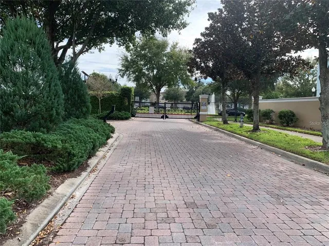 a front view of a house with a yard and large trees