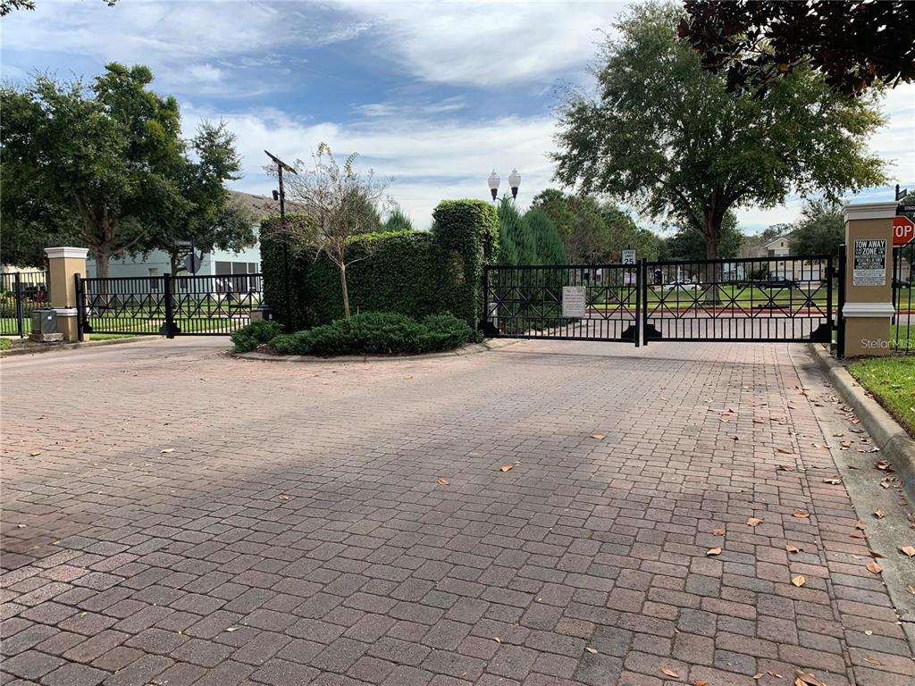 3121 Capri Isle Way Orlando, FL 32835 - Photo 36 of 37 a view of a patio with a table and chairs and a barbeque with wooden fence