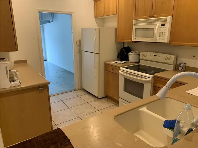 a kitchen with a stove top oven and refrigerator