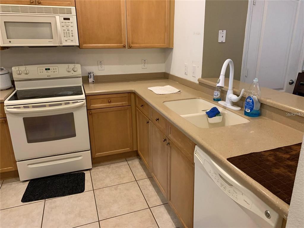 3121 Capri Isle Way Orlando, FL 32835 - Photo 5 of 37 a kitchen with a sink cabinets and appliances