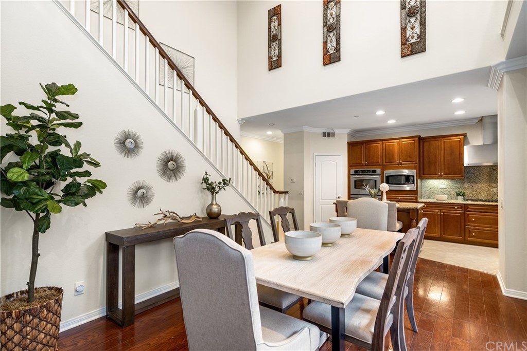 51 Secret Garden Irvine, CA 92620 - Photo 9 of 28 a dining room with furniture potted plants and wooden floor