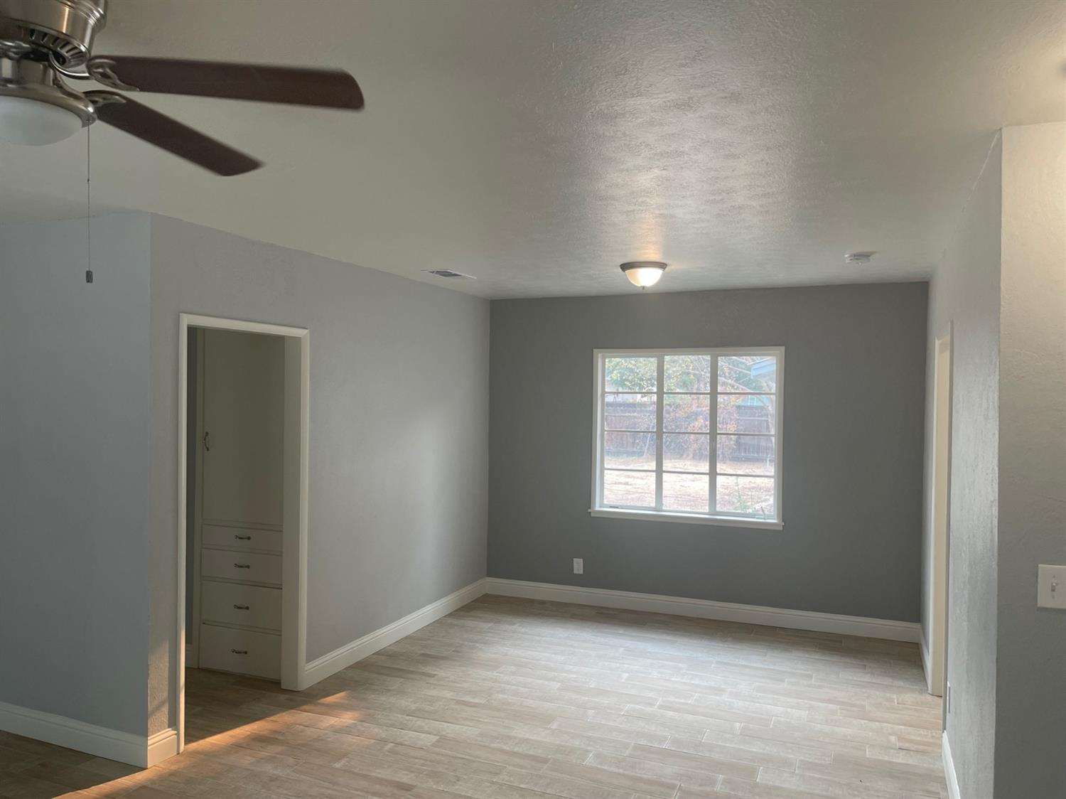1246 South Klein Avenue Reedley, CA 93654 - Photo 6 of 10 an empty room with windows and fan