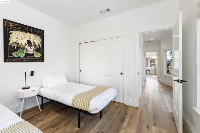 a spacious bedroom with two beds and a wooden floor