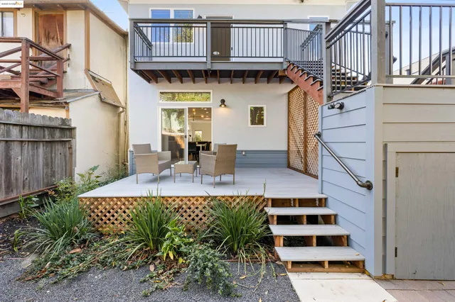 a view of backyard with outdoor seating and wooden fence