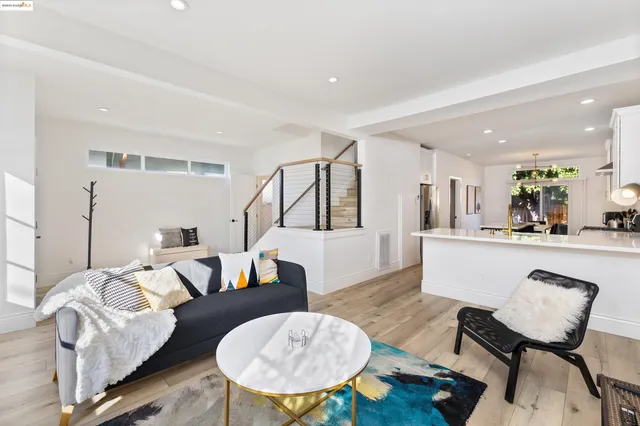 a living room with furniture and a dining table with wooden floor
