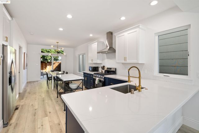 a kitchen with stainless steel appliances a table and chairs in it