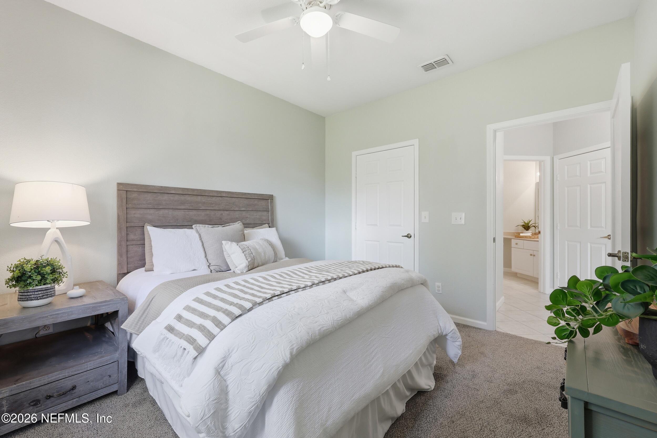 1529 Vista Cove Road St. Augustine, FL 32084 - Photo 35 of 75 a bedroom with a bed and a chandelier