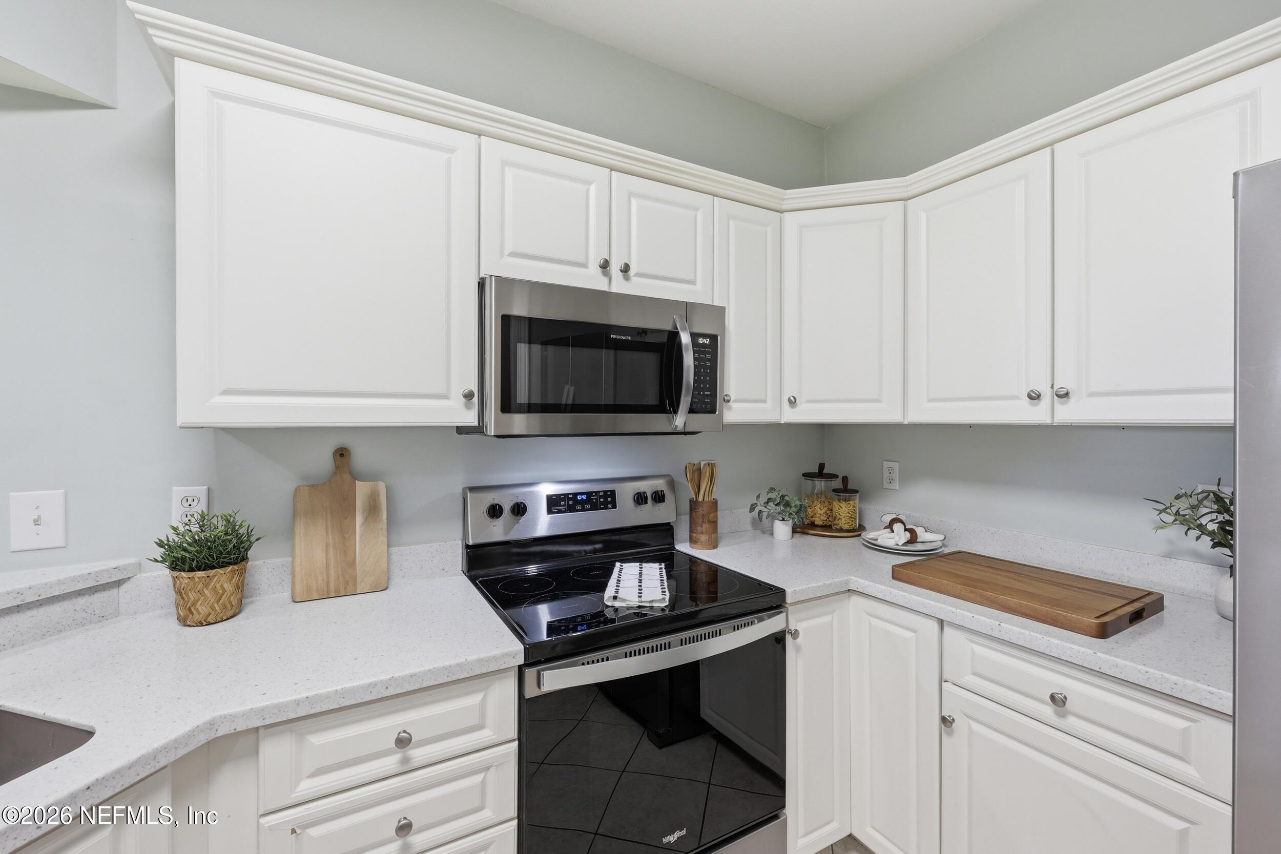 1529 Vista Cove Road St. Augustine, FL 32084 - Photo 9 of 75 a kitchen with stainless steel appliances white cabinets and a stove top oven