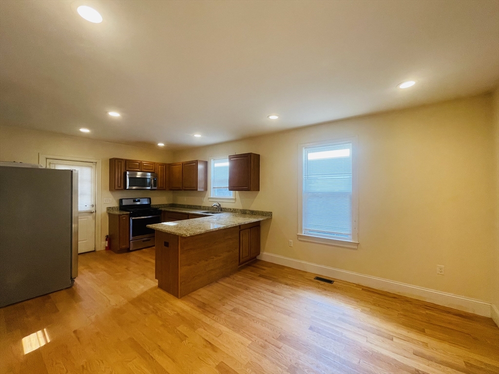 a kitchen with stainless steel appliances granite countertop a stove and a refrigerator