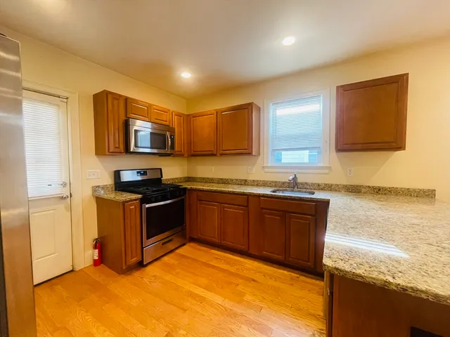 a kitchen with stainless steel appliances granite countertop a stove a sink and a refrigerator