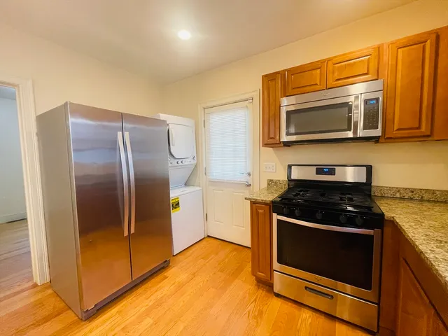 a kitchen with stainless steel appliances granite countertop a stove a microwave and a refrigerator