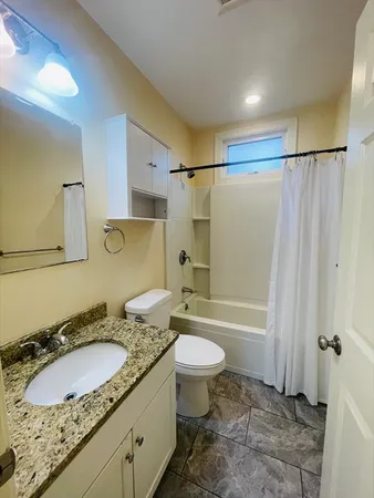 a bathroom with a granite countertop sink toilet and shower