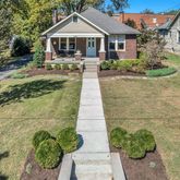 a front view of a house with yard and green space