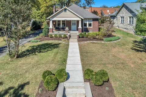 a front view of a house with yard and green space