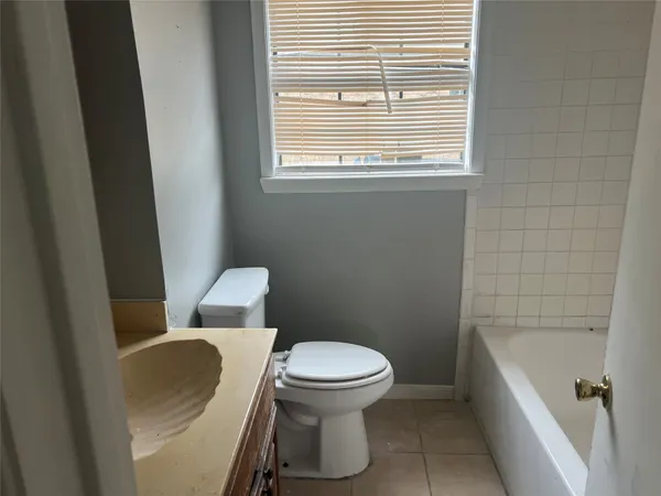 a white toilet sitting next to a bathroom sink and vanity
