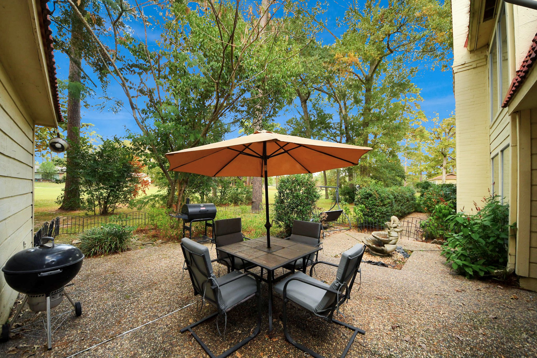 17 Winged Foot Drive Conroe, TX 77304 - Photo 44 of 46 a view of a backyard with table and chairs under an umbrella