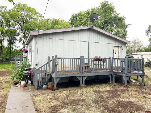 a backyard of a house with a deck and furniture