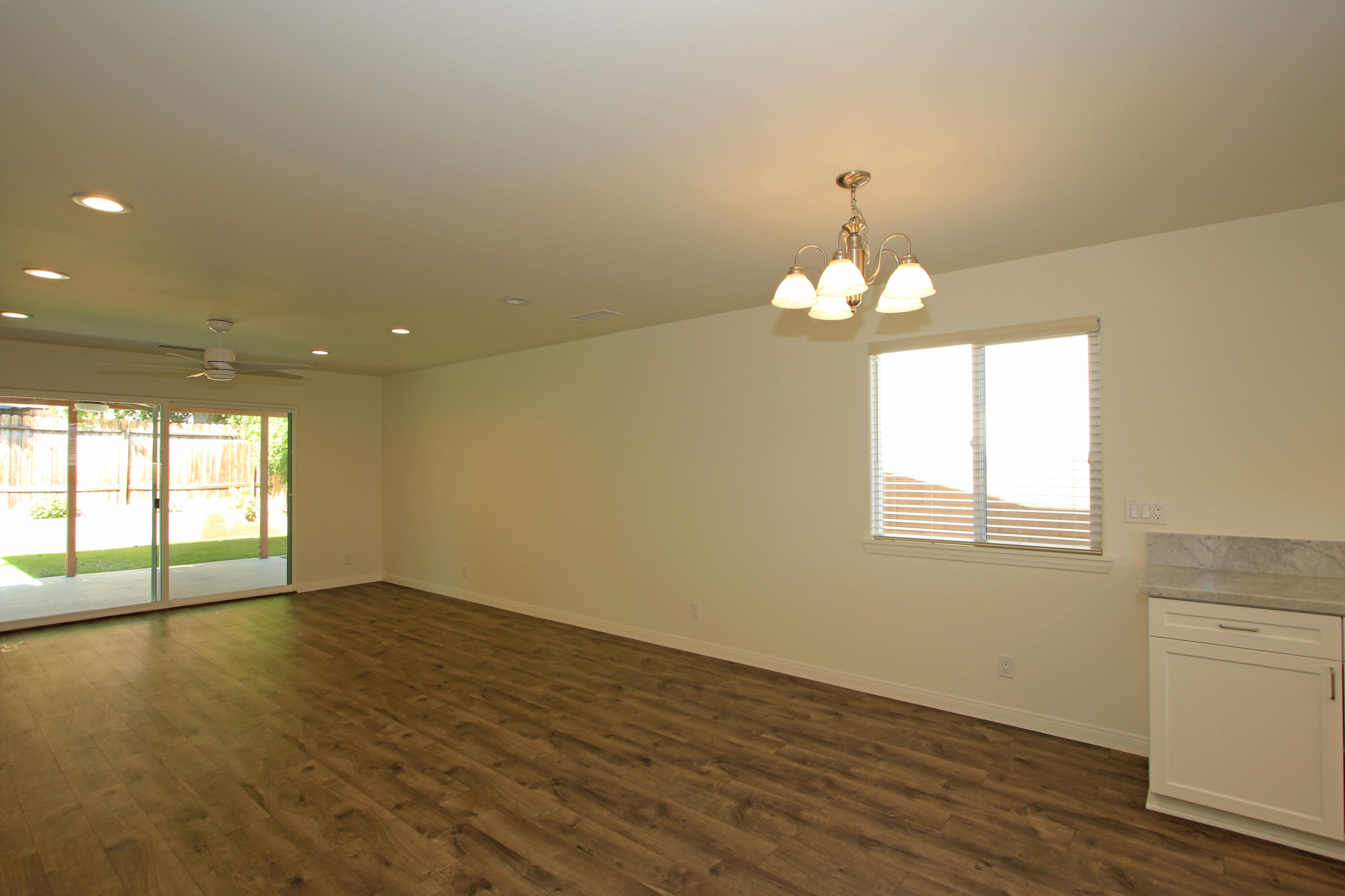 51845 Eisenhower Drive La Quinta, CA 92253 - Photo 17 of 35 an empty room with wooden floor and windows