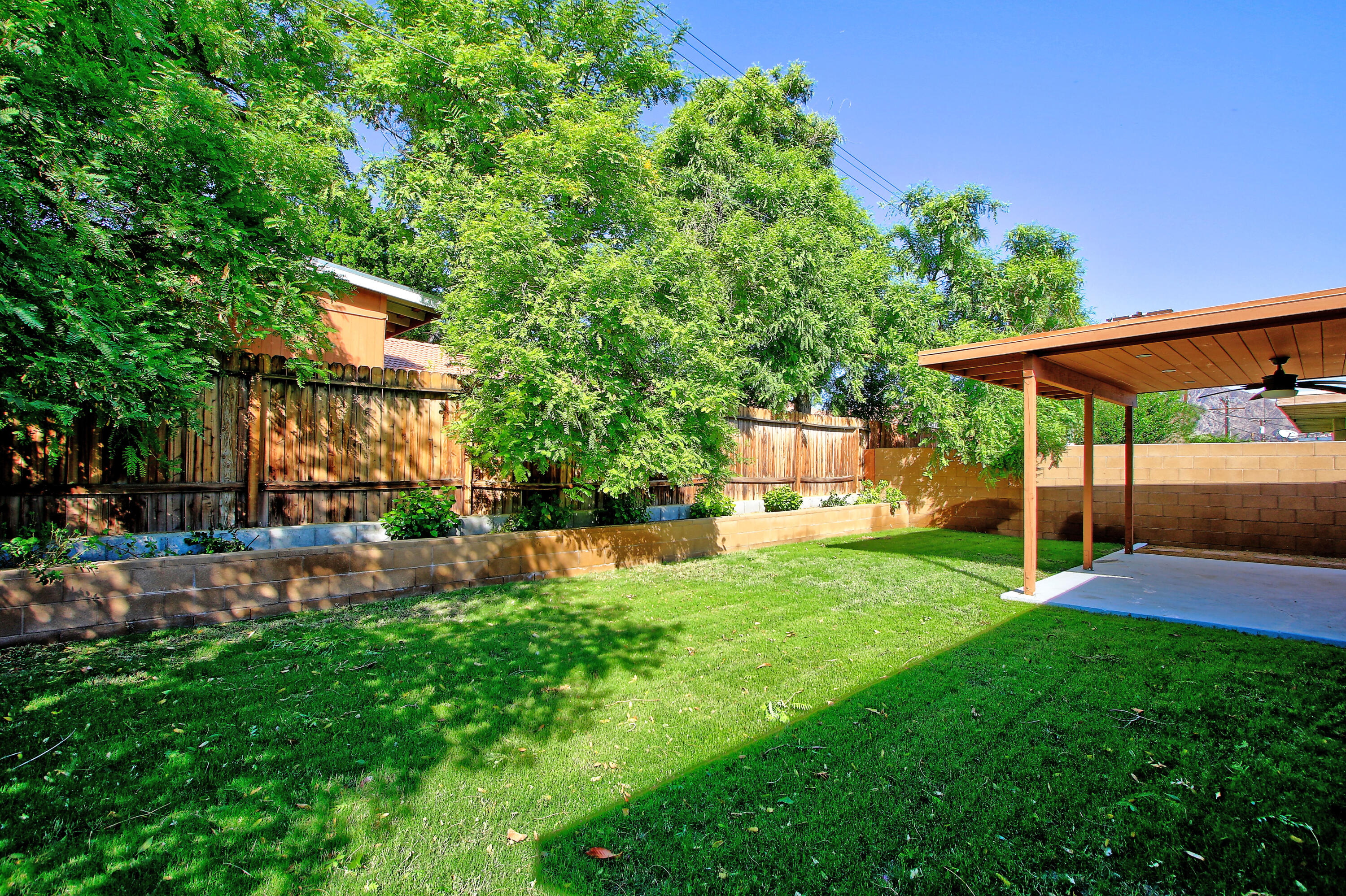 51845 Eisenhower Drive La Quinta, CA 92253 - Photo 32 of 35 a view of a backyard with table and chairs under an umbrella