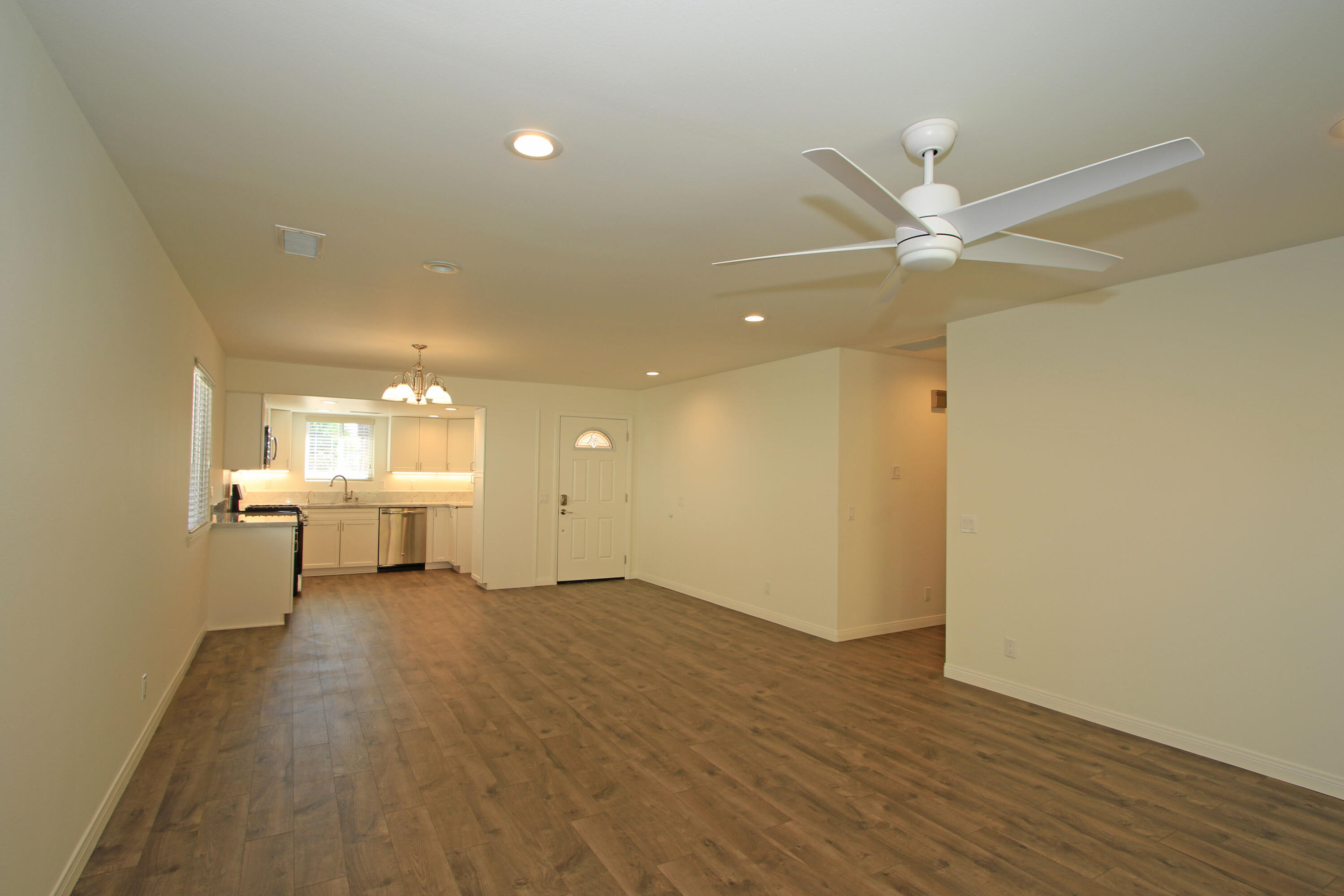 51845 Eisenhower Drive La Quinta, CA 92253 - Photo 8 of 35 an empty room with a wooden floor and a ceiling fan