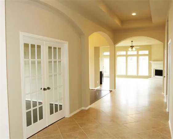 a view of a hallway with wooden floor and a bathroom