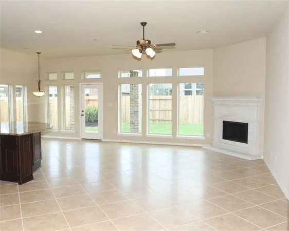 a view of an empty room with a fireplace and a window