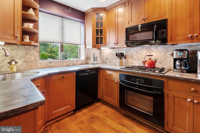 a kitchen with stainless steel appliances granite countertop a sink stove and microwave