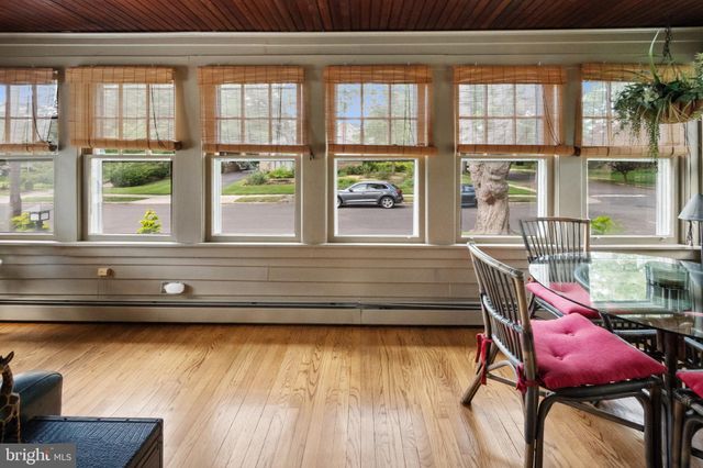 a room with a table chairs wooden floor and windows