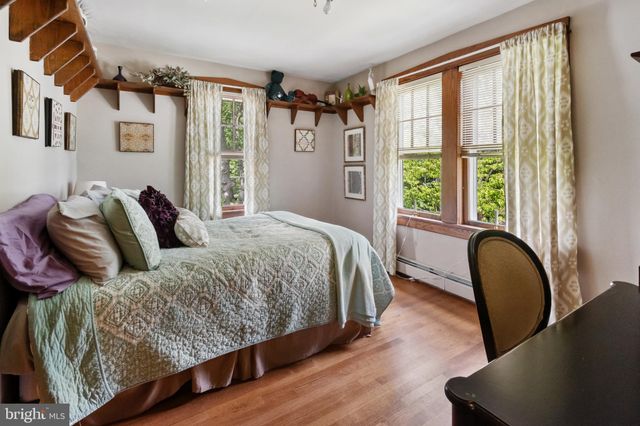 a bedroom with a bed a couch and a large window