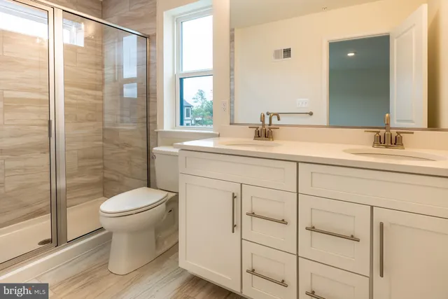 a bathroom with a sink a toilet and shower