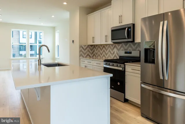 a kitchen with a refrigerator and a wooden floor