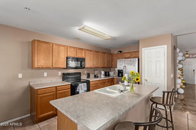 a kitchen with a table chairs microwave and cabinets