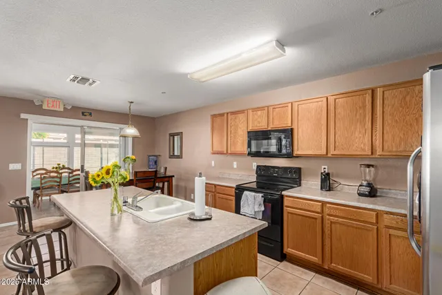a kitchen with stainless steel appliances granite countertop a stove a sink a microwave a dining table and chairs
