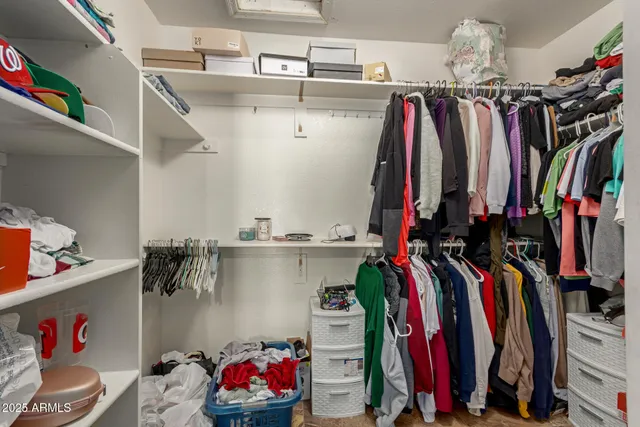 a view of walk in closet with clothes and shoes
