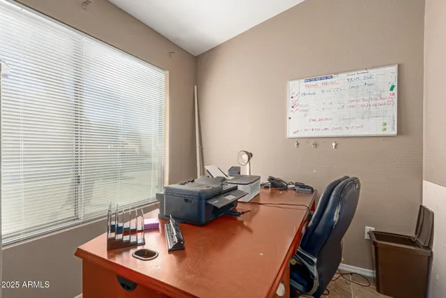 a view of a workspace with furniture and a window