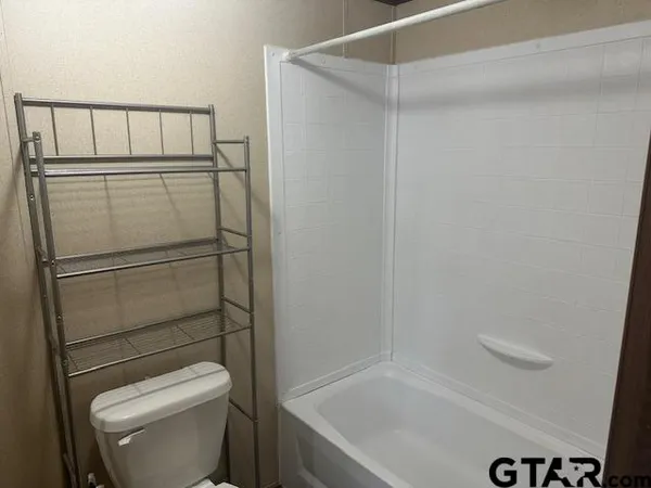 a bathroom with a shower a toilet and a sink