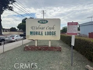 a sign board with a house and a yard