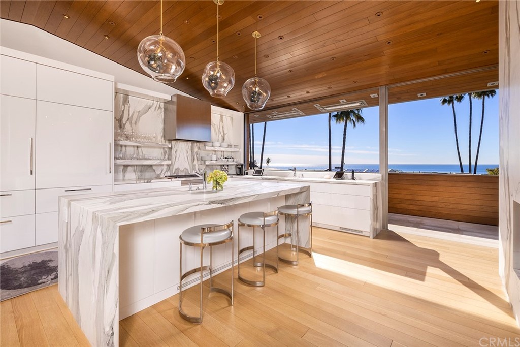 2538 Monaco Drive Laguna Beach, CA 92651 - Photo 4 of 26 a kitchen with stainless steel appliances a table chairs in it and wooden floors