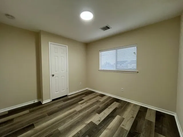 a bedroom with a large bed window and closet