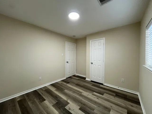 a spacious bedroom with a large bed and a chandelier