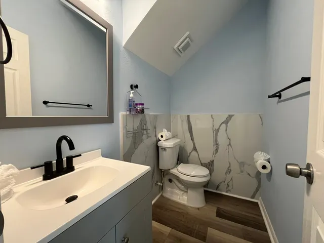 a bathroom with a toilet sink and mirror