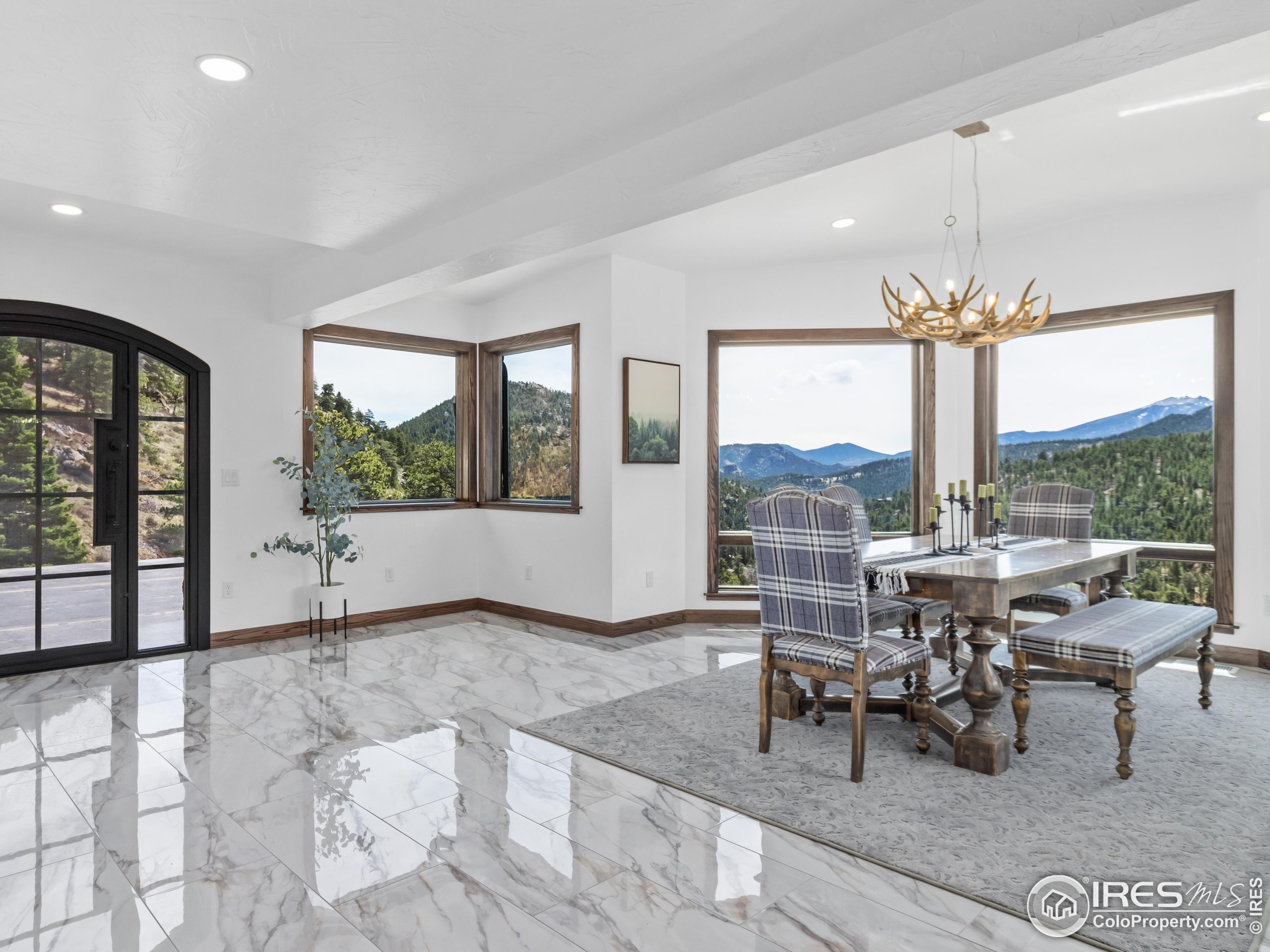 2701 Fall River Road Estes Park, CO 80517 - Photo 15 of 40 a view of a dining room with furniture large windows and a chandelier