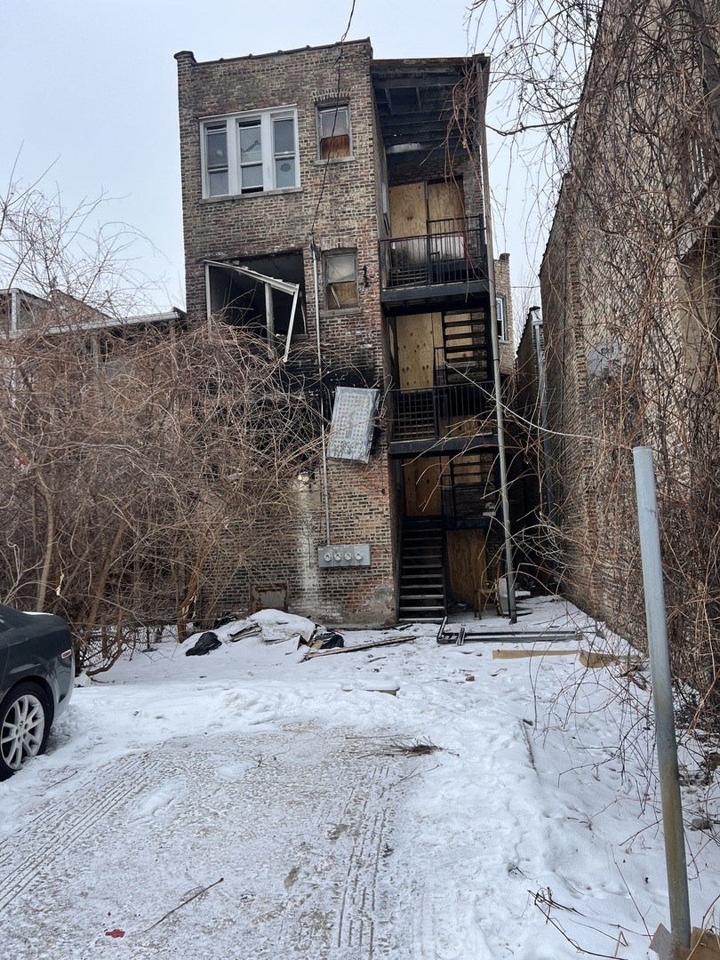 3827 West Fillmore Street Chicago, IL 60624 - Photo 2 of 23 a backyard of a house with glass top table and chairs